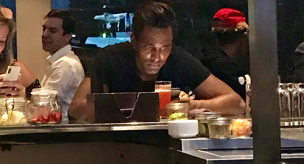Male at bar looking at phone
