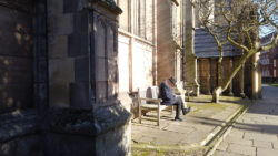 Man sitting on bench outside church