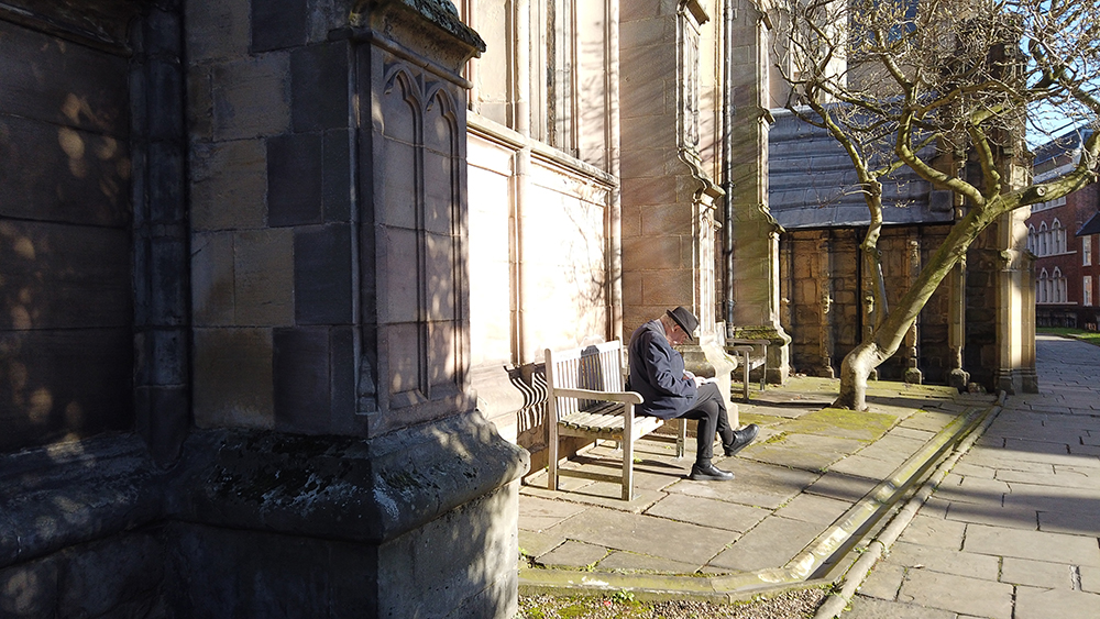 Man sitting on bench outside church