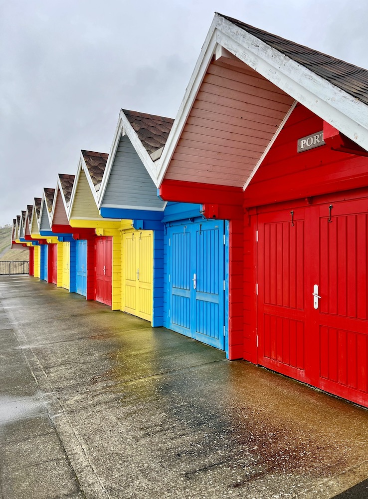 the colourful beach houses on Whitby beach