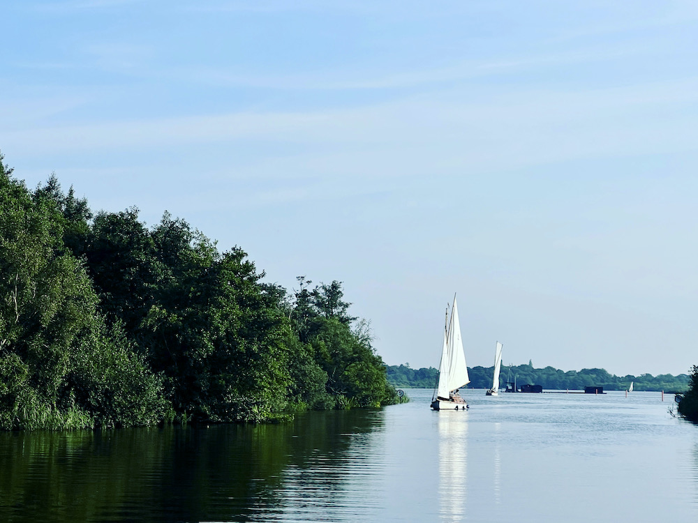 a yacht sailing along the river in Norfolk