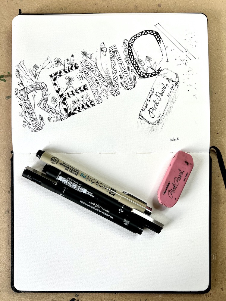 A sketchbook and fine liners depicting an ink drawing