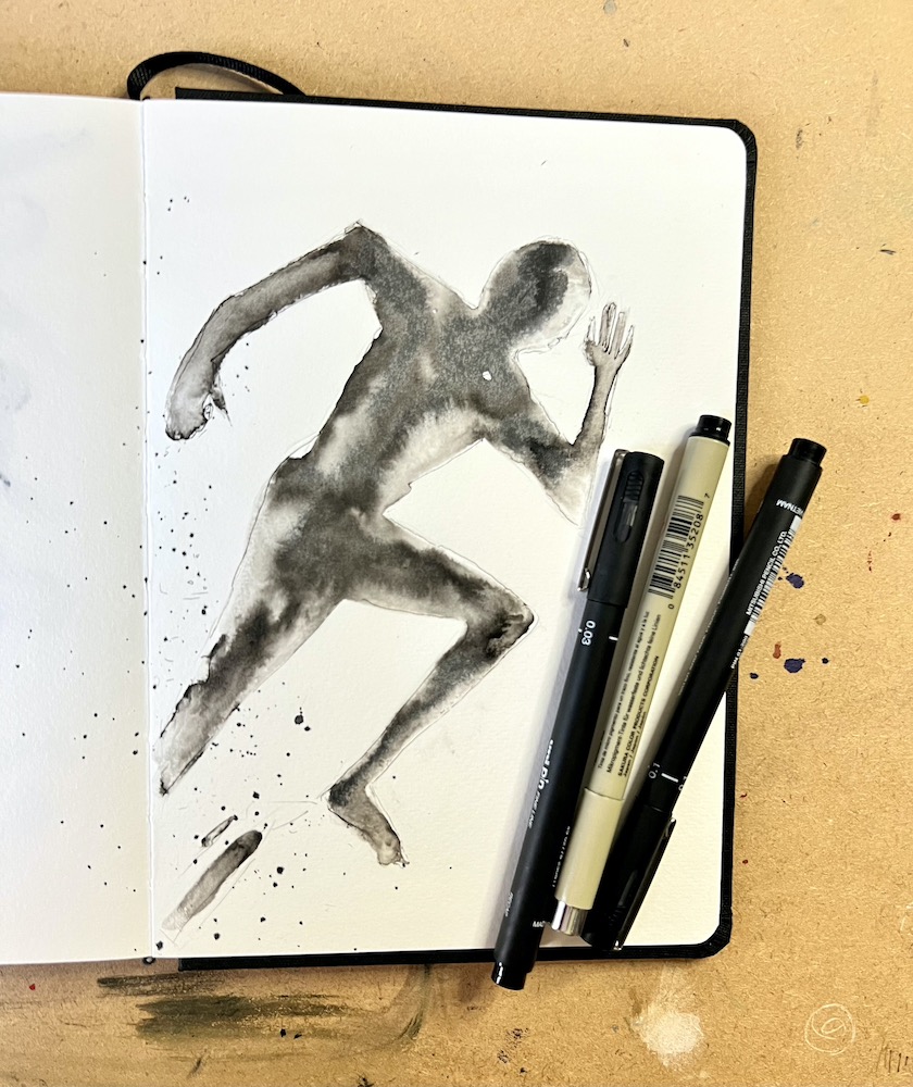 sketch book and pens of a person running drawn in ink
